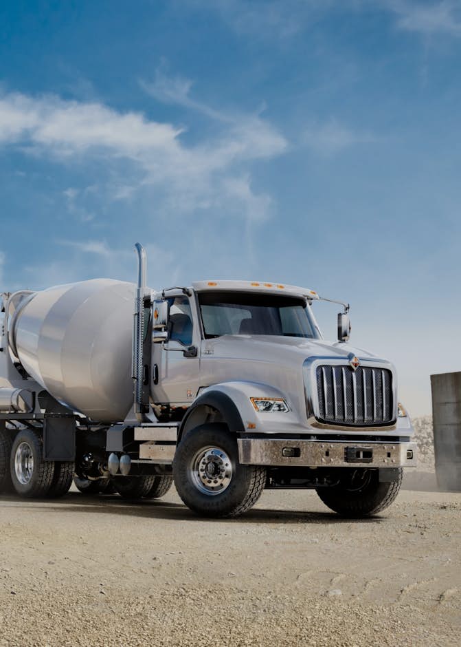 A concrete mixer truck on a dirt road