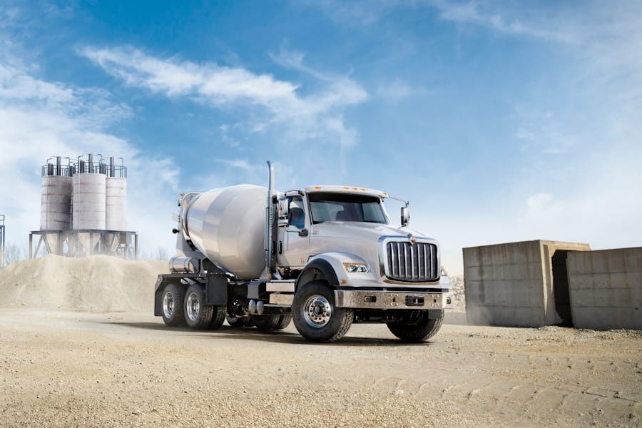 A concrete mixer truck on a dirt road