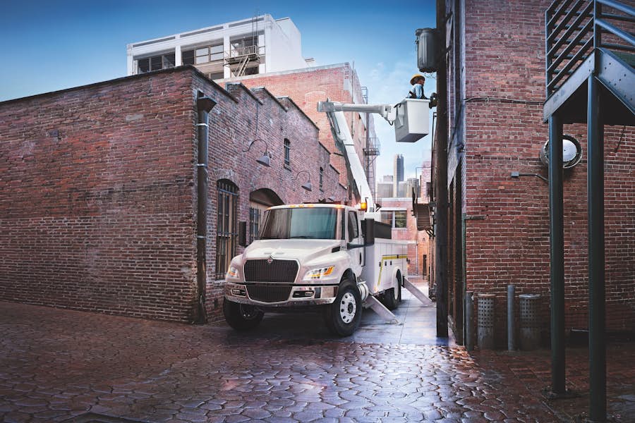 A white truck parked in a brick alley