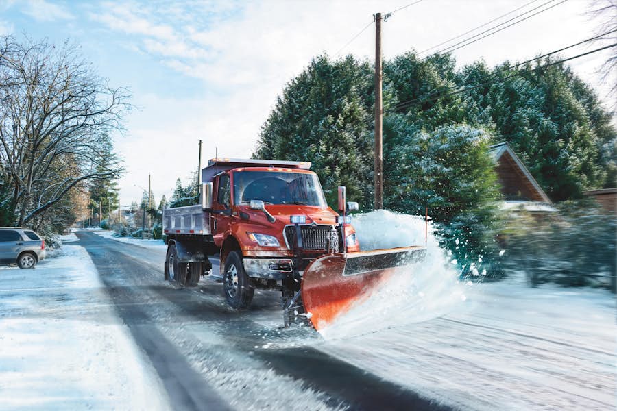 A snow plow truck on a snowy road