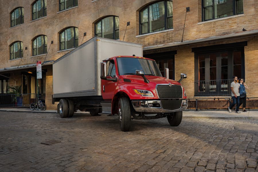 A red truck parked in front of a brick building