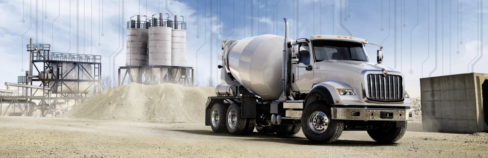 White cement truck driving through dirt