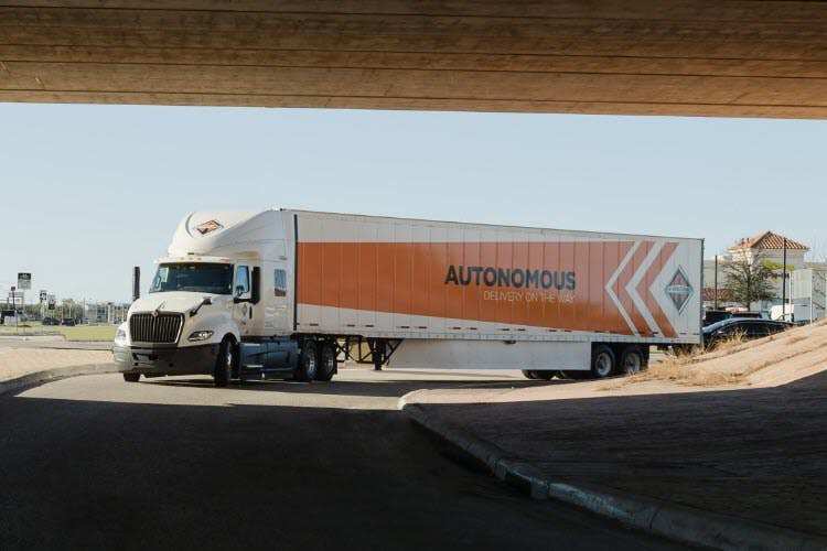 A truck driving under a bridge