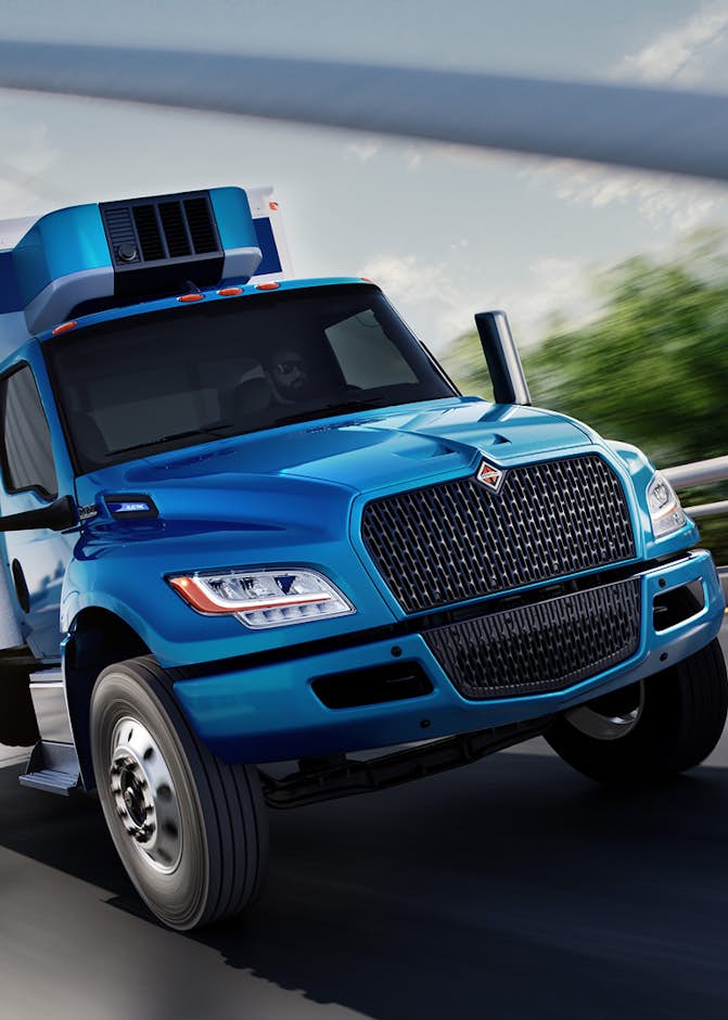 Blue truck driving on road under bridge