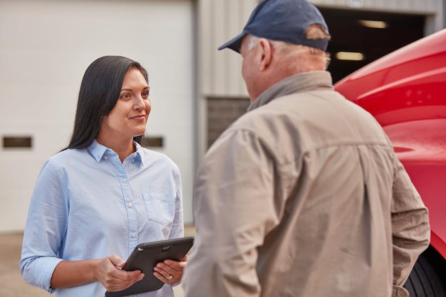 A person holding a tablet and looking at a person