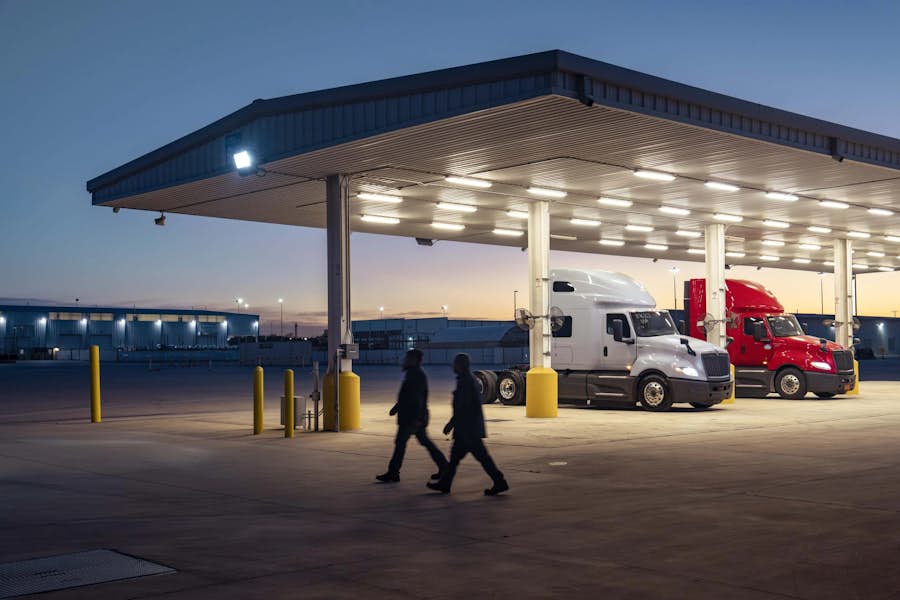 A couple of people walking under a covered building
