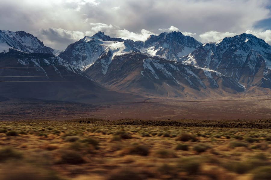 A snowy mountain range with a cloudy sky