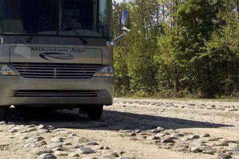 A front view of a vehicle on a dirt road