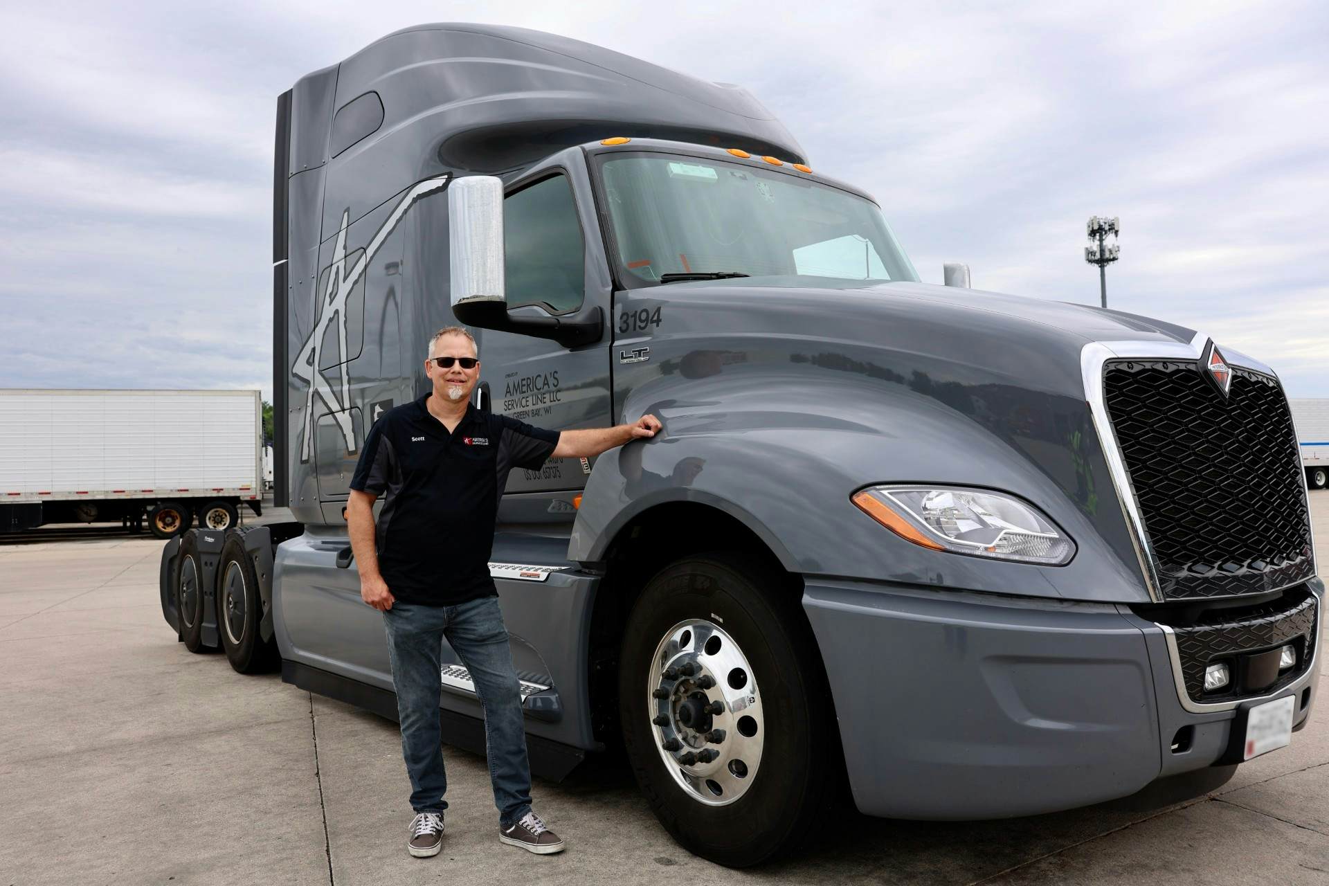 Man standing next to grey LT Series commercial truck